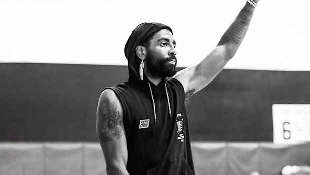 Kyrie Irving waves in a photo shoot.